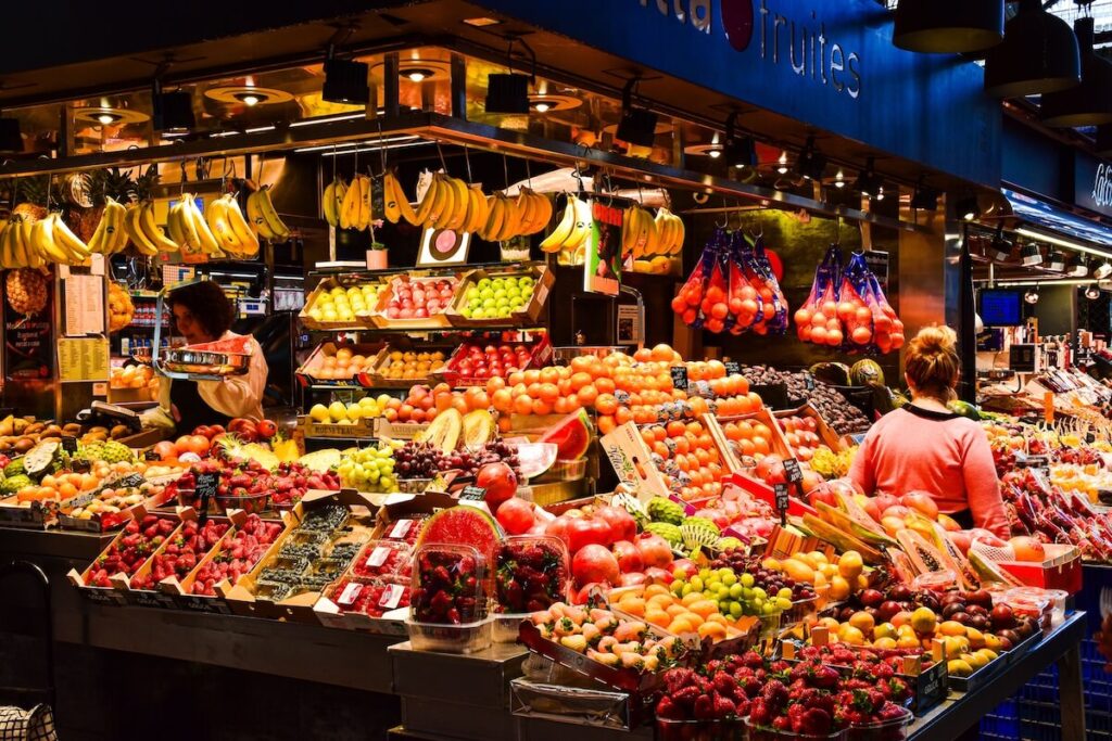 Colorful fruit display at a bustling market in Barcelona, Spain