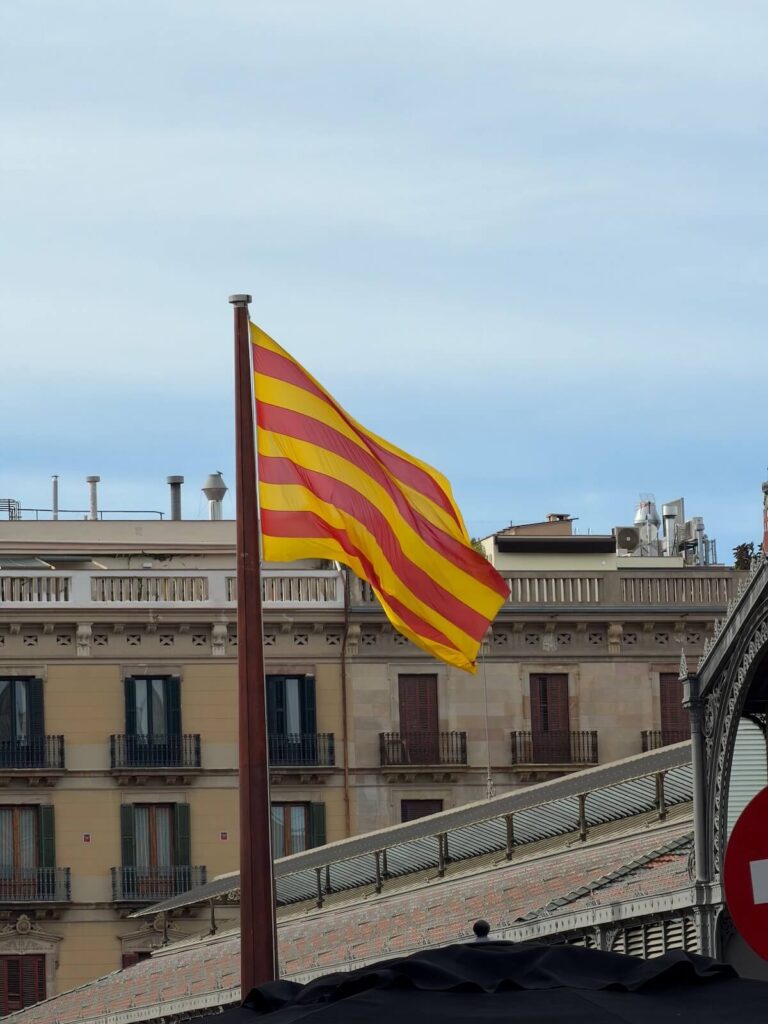 Catalonia flag waving against Barcelona skyline