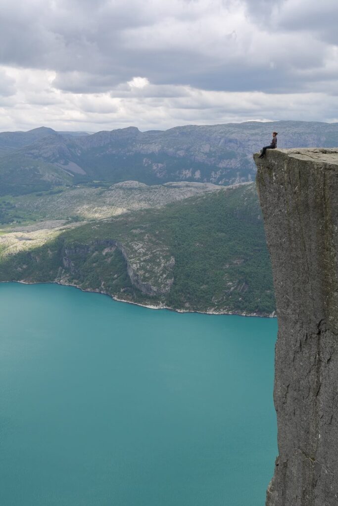 woman sitting at the edge of Pulpit Rock in Norway