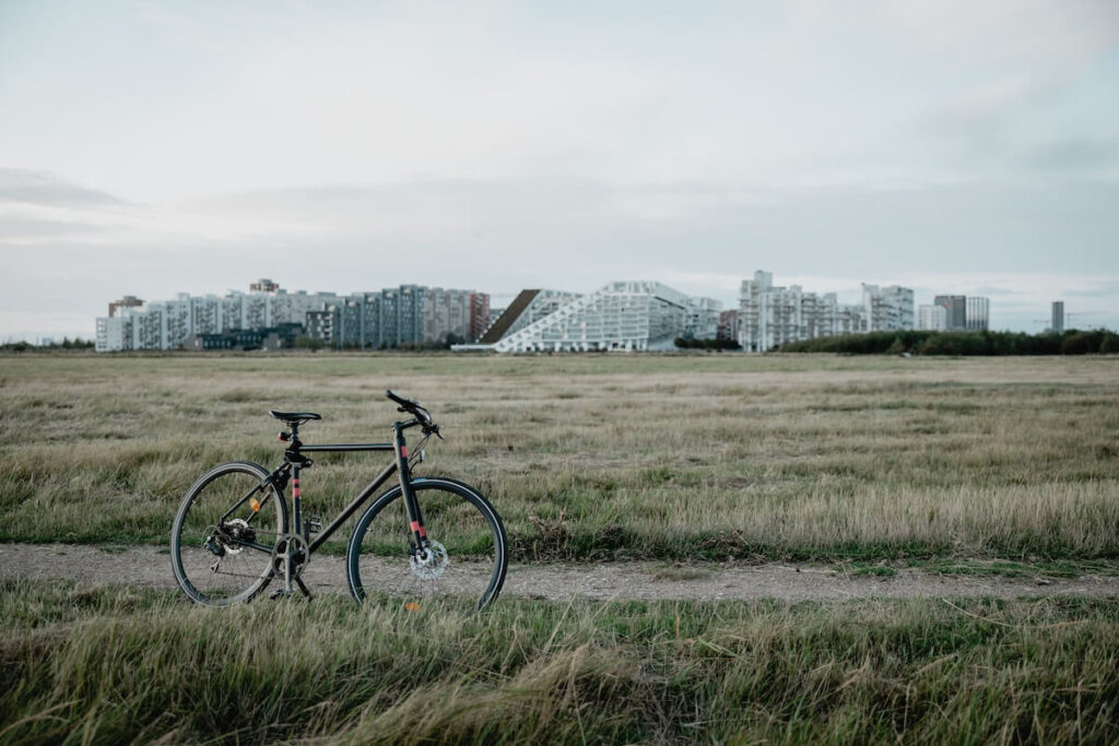 bicycle parked in the grass field, with CopenHill in the background