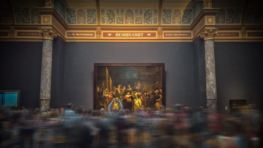 people looking at Rembrandt's painting "The Night Watch" at the Rijksmuseum
