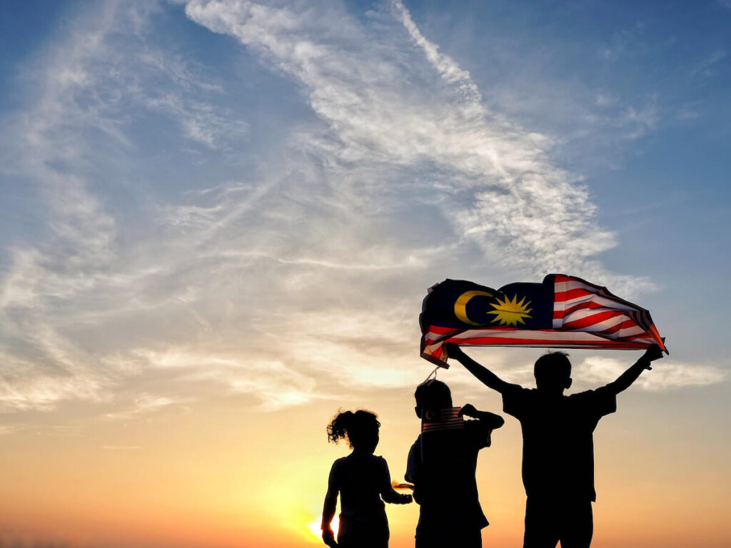 silhouette of teens holding Malaysian flag