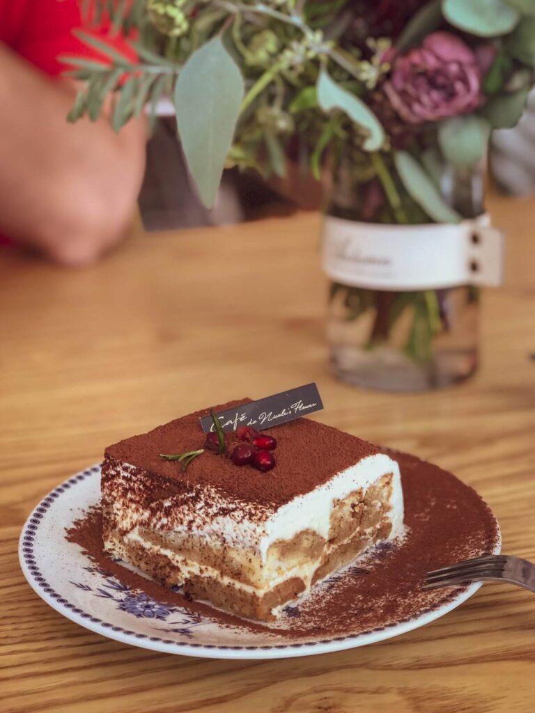 Tiramisu cake on a coffee table with a man on the background