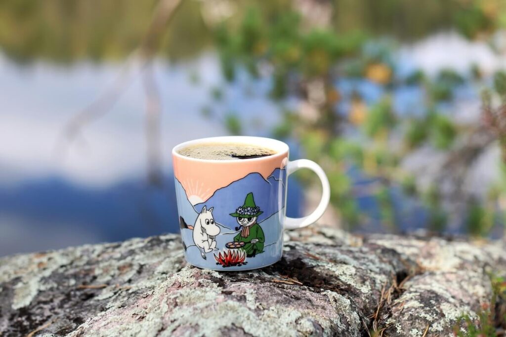 coffee-filled Moomin mug on top of rock