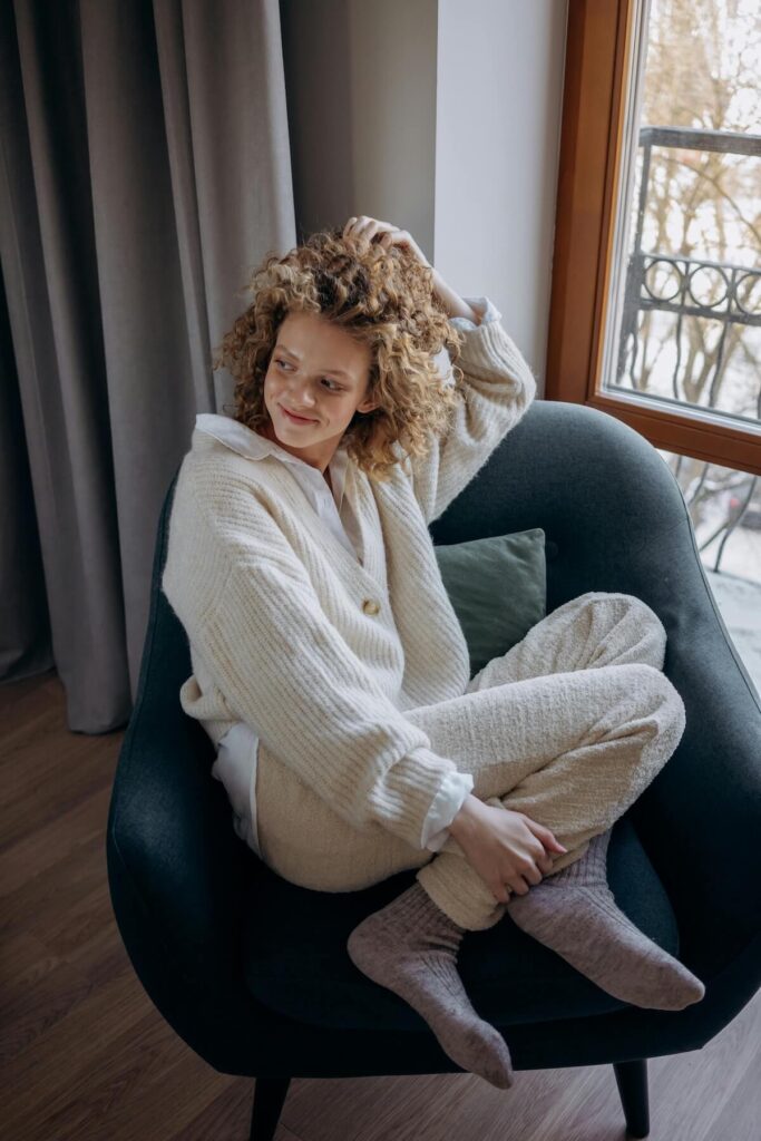woman cozying up in a chair wearing socks