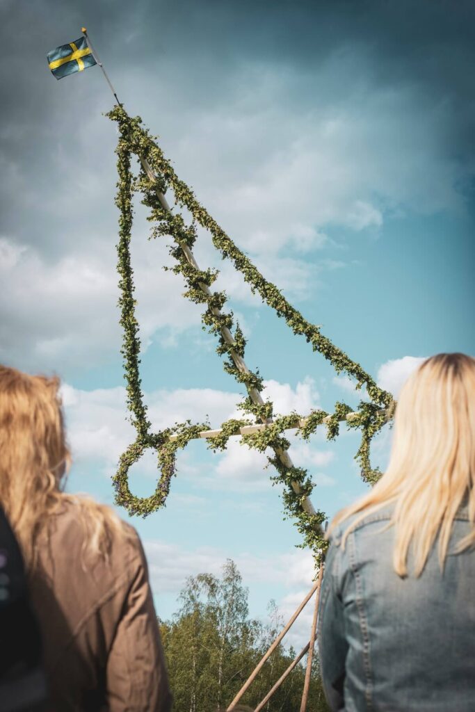 two women facing maypole in Sweden
