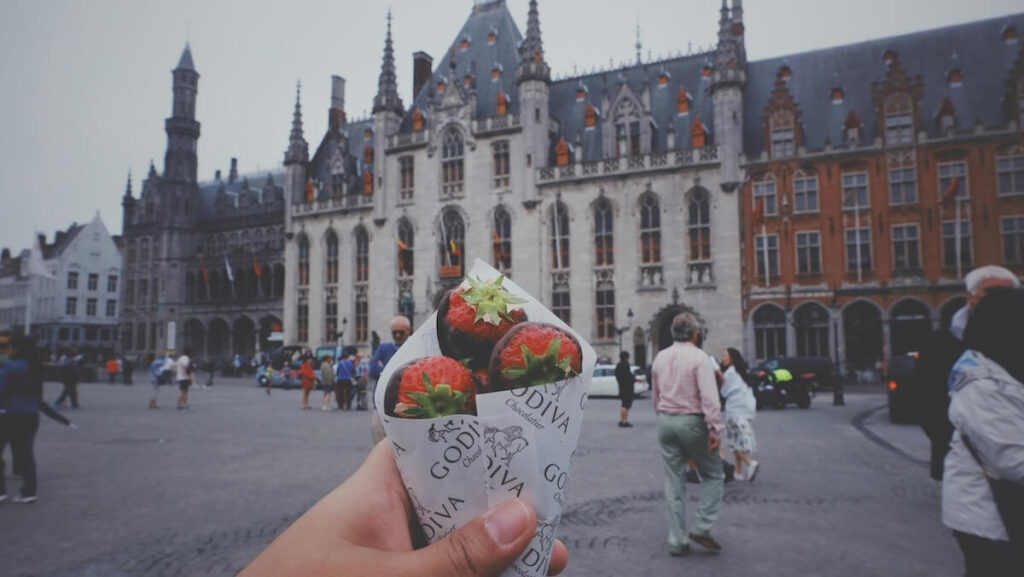 person holding Godiva strawberry chocolates in Belgium