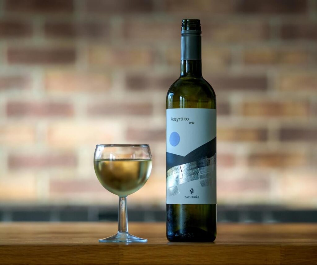 a bottle of Assyrtiko wine and a wine glass
