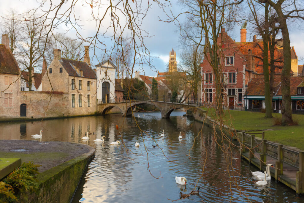 Landscape at Lake Minnewater with church and bridge in Bruges, Belgium