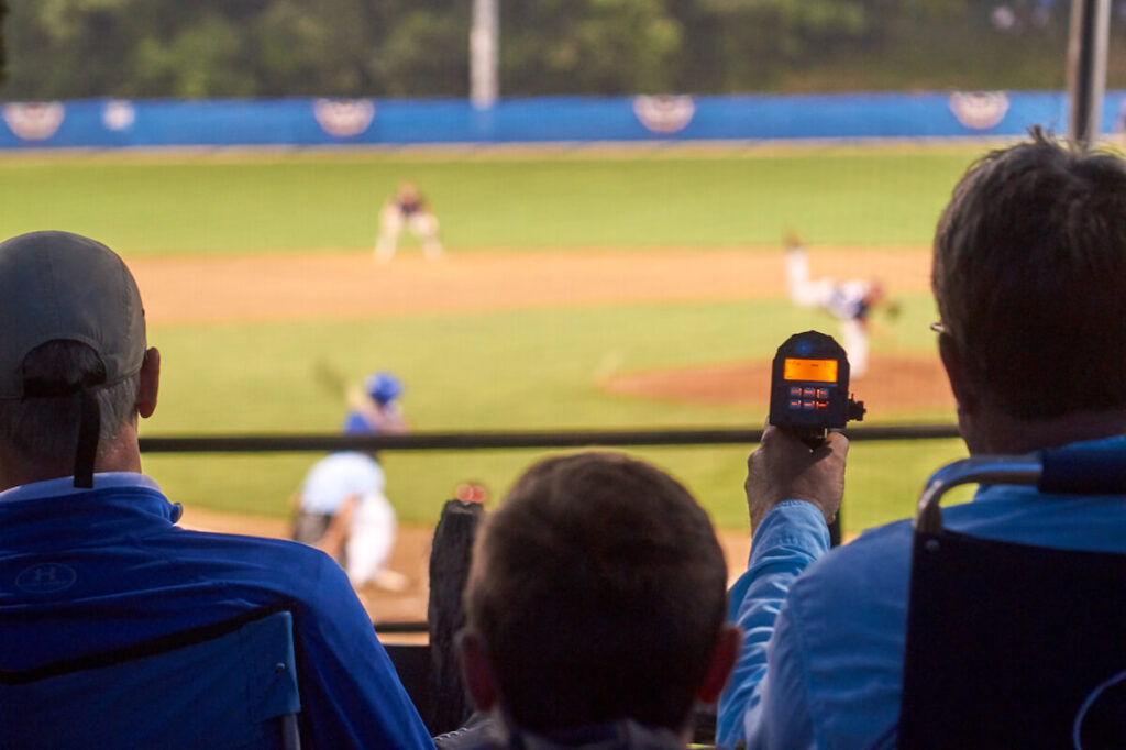 Talent scouts with radar guns during a baseball game in Cape Cod