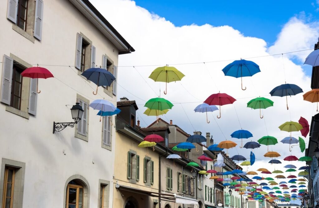 Multicolored umbrellas in the sky above the street in the Carouge area of Geneva