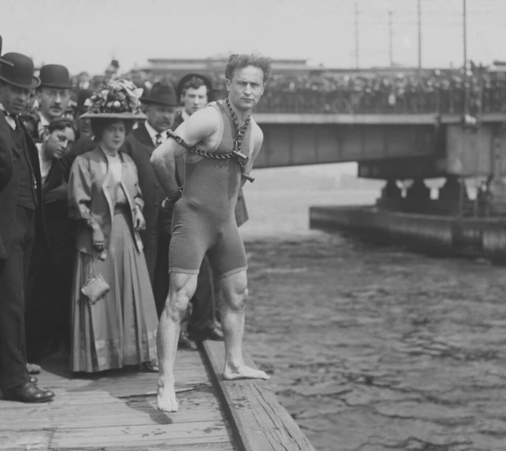 Harry Houdini jumps 30 feet from Harvard Bridge locked up in chains
