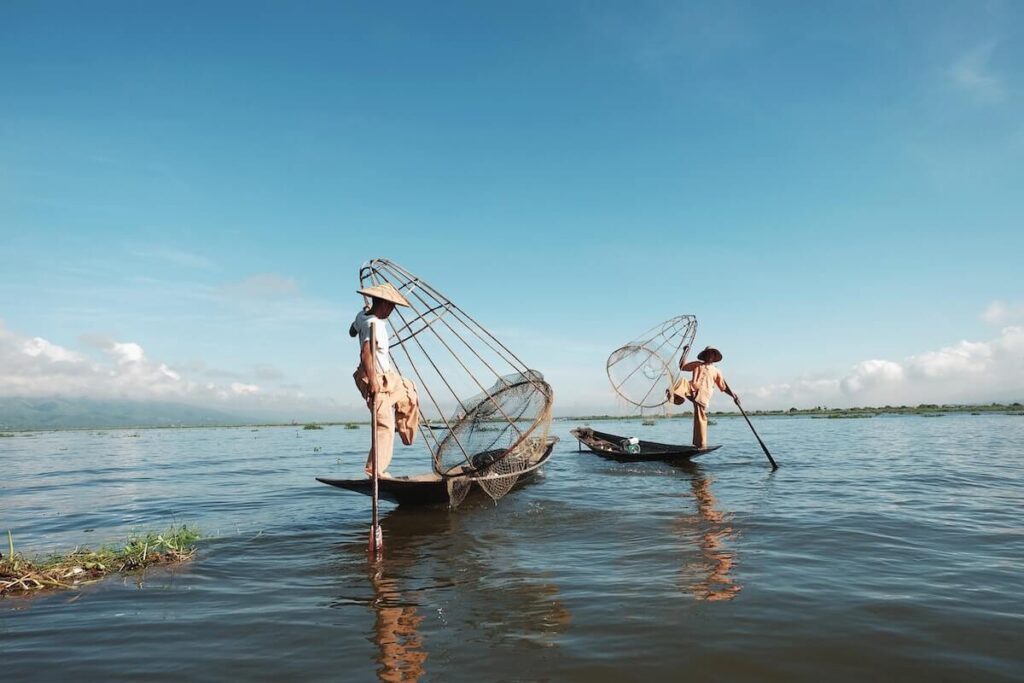 fishermen fishing at Inle Lake in Myanmar with one leg paddling