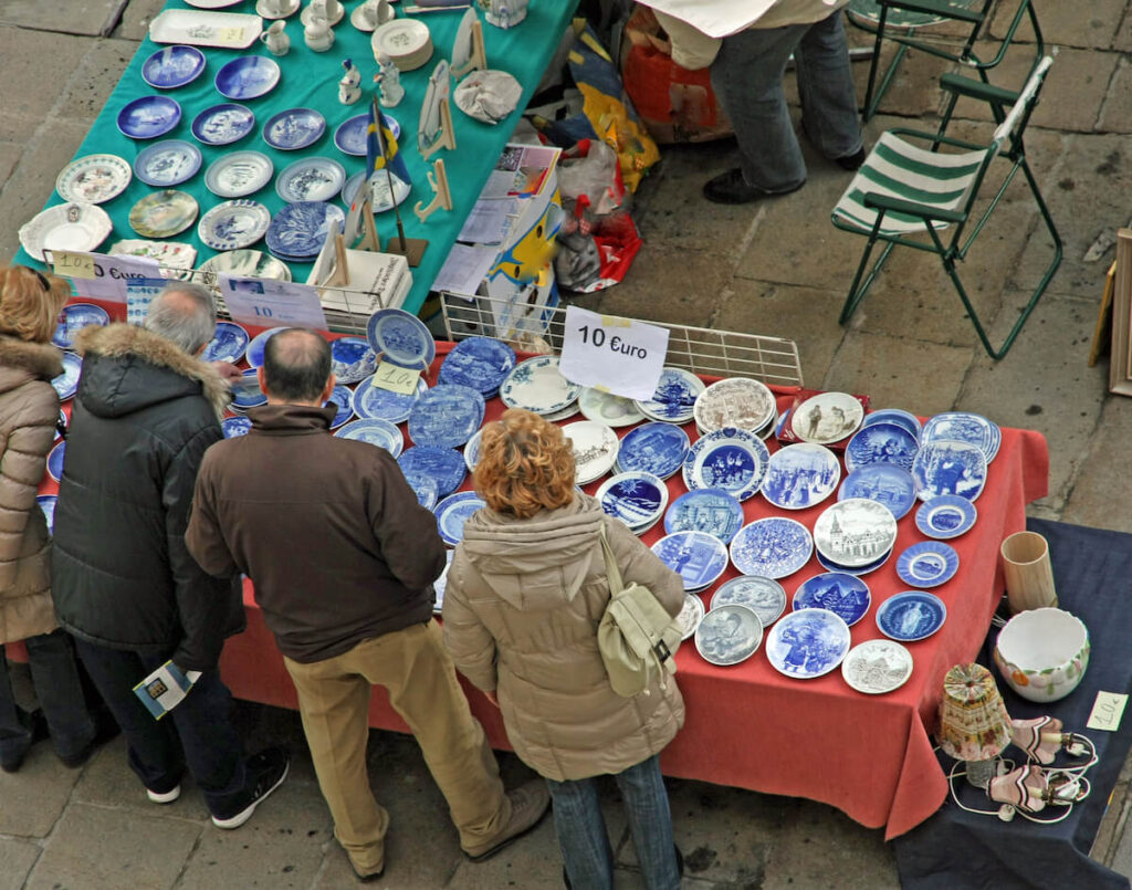 people shopping for decorated plates for sale at the market