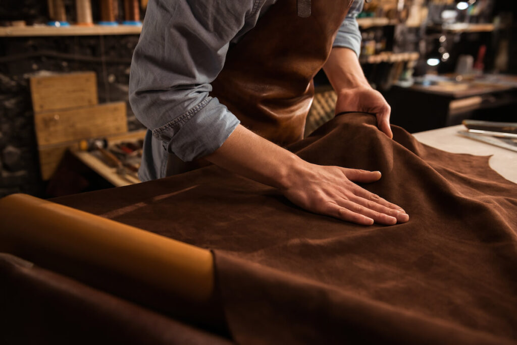 male shoemaker working with leather textile at his workshop