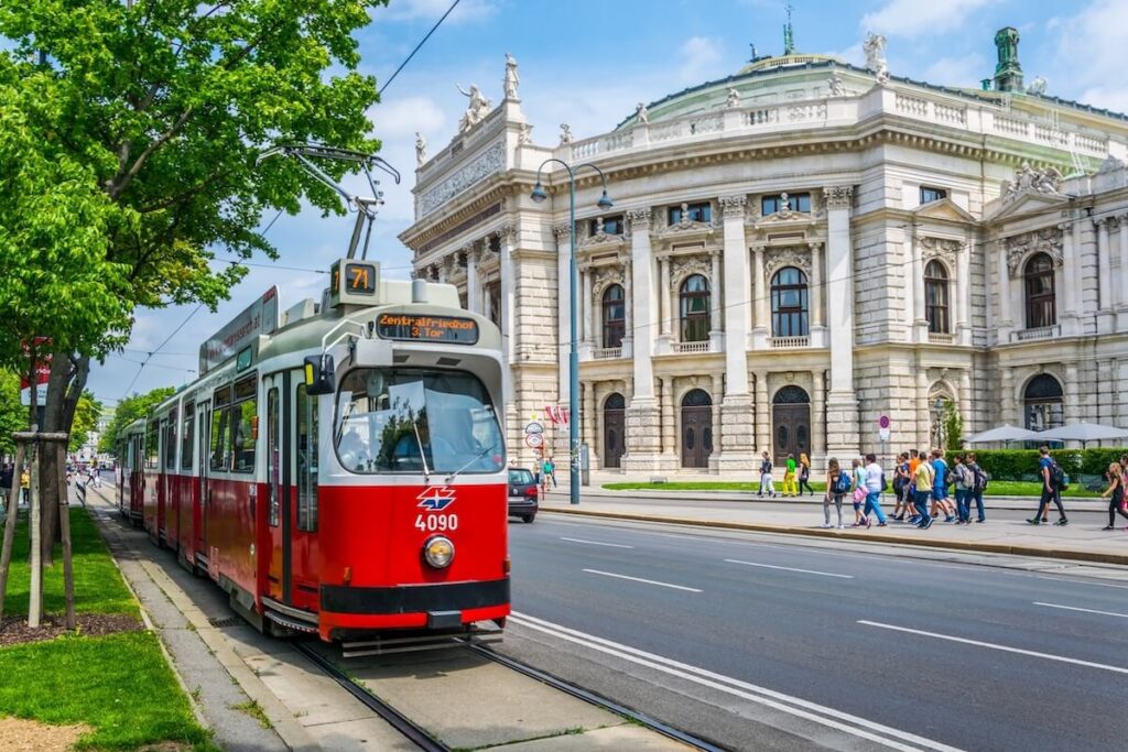 Famous Wiener Ringstrasse with historic Burgtheater (Imperial Court Theatre) and traditional red electric tram