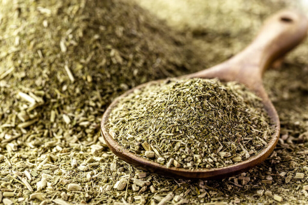 wooden spoon with yerba mate on background