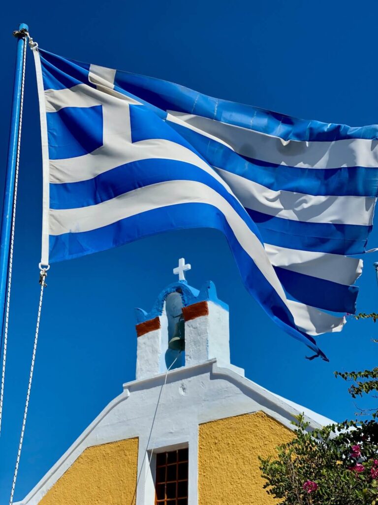 The Greek flag outside a Greek Orthodox Church in Santorini, Greece