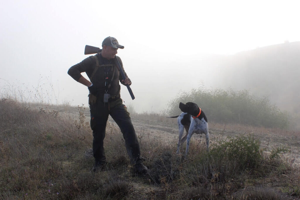 man with his hunting dog and rifle
