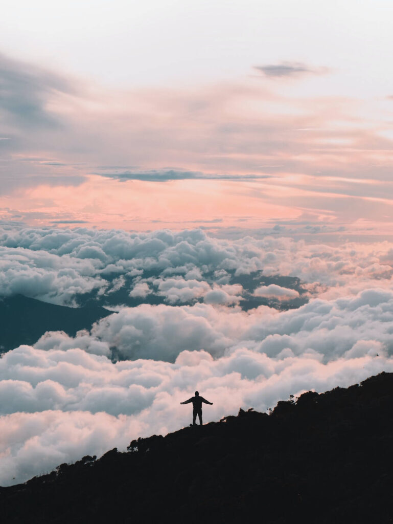 man surrounded by clouds on top of Mount Kinabalu, one of the most famous natural wonders in Malaysia