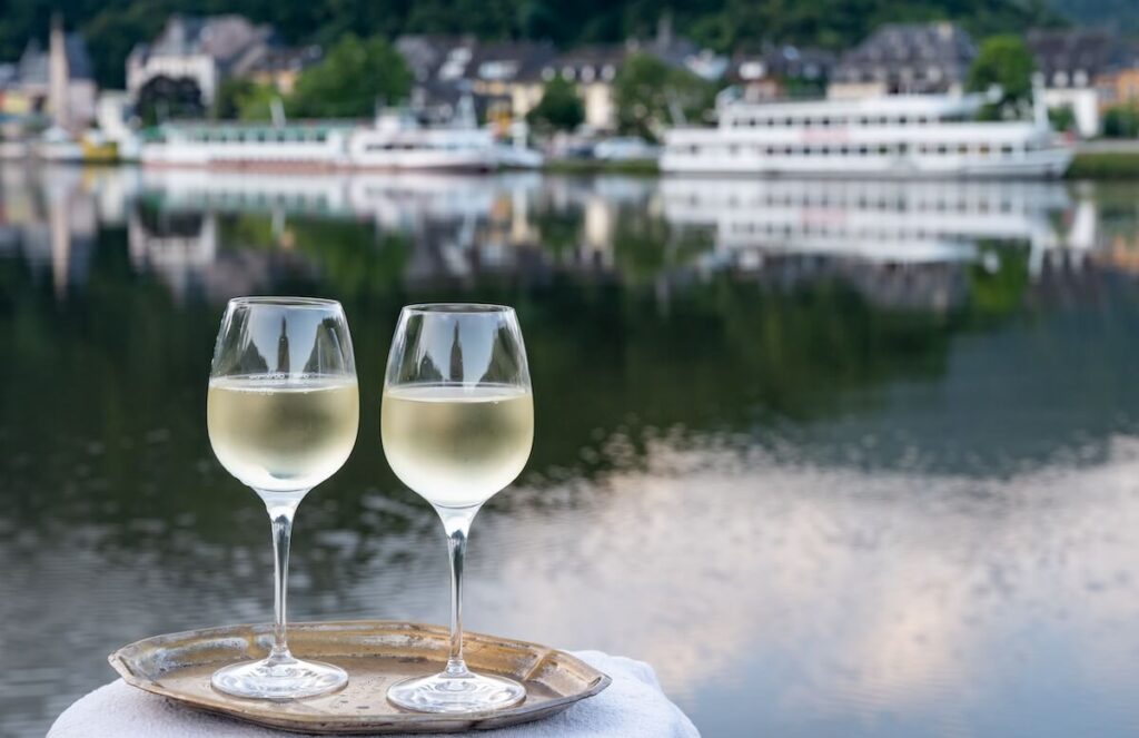 Tasting of white quality riesling wine served on outdoor terrace in Mosel wine region