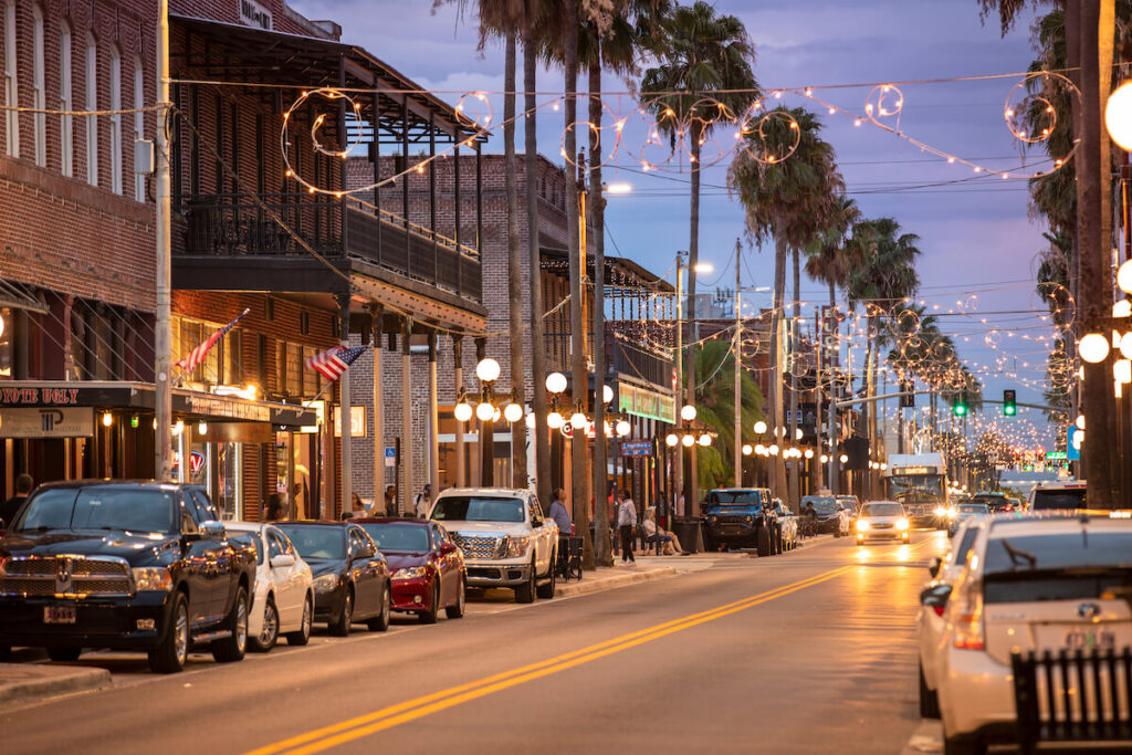People walk along the downtown nightlife of bars and restaurants in historic Ybor City, Tampa, Florida