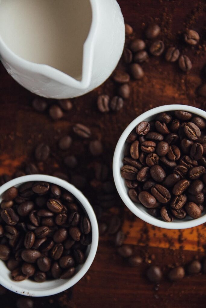 flatlay shot of coffee beans in cups and wooden table