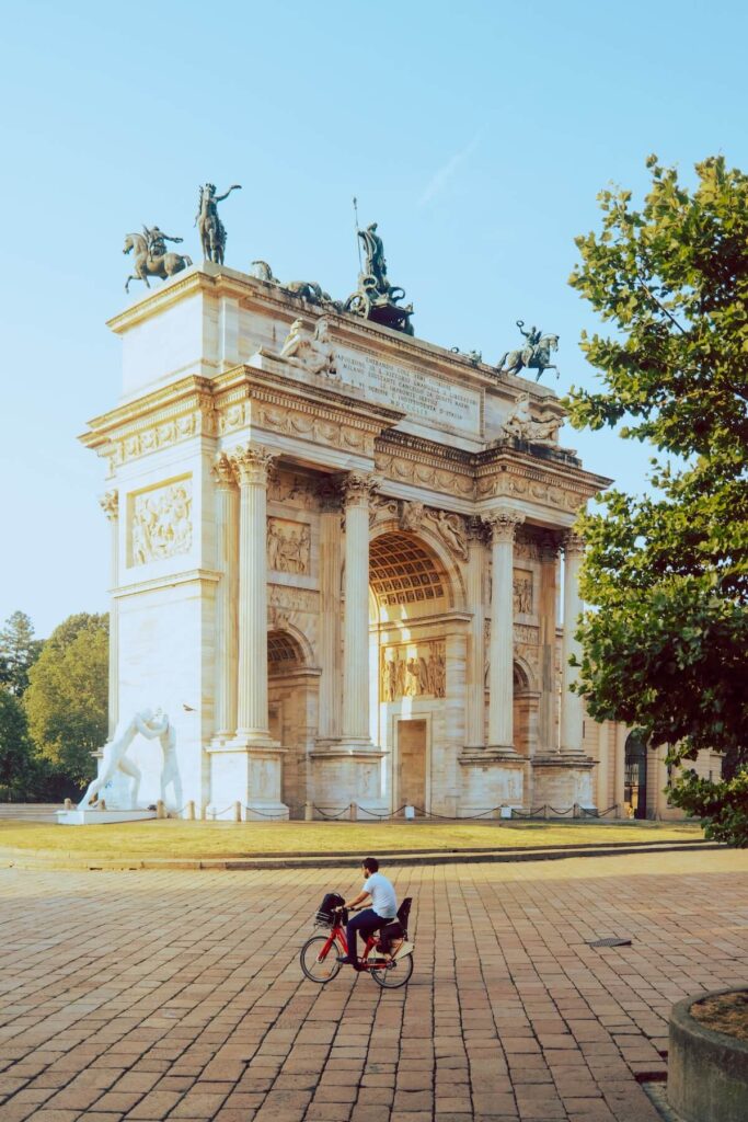 man riding bike near arco della pace