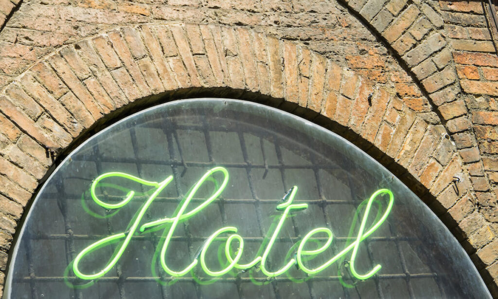 Green neon light hotel sign on the wall, Florence, Tuscany, Italy