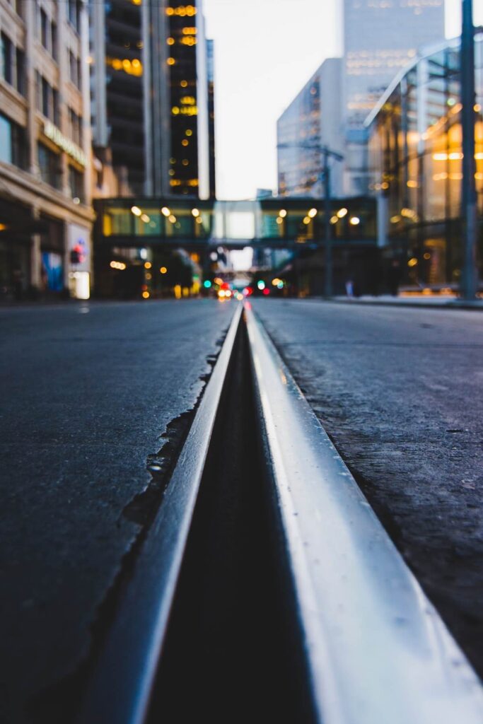 polished road and tram line in city at dusk