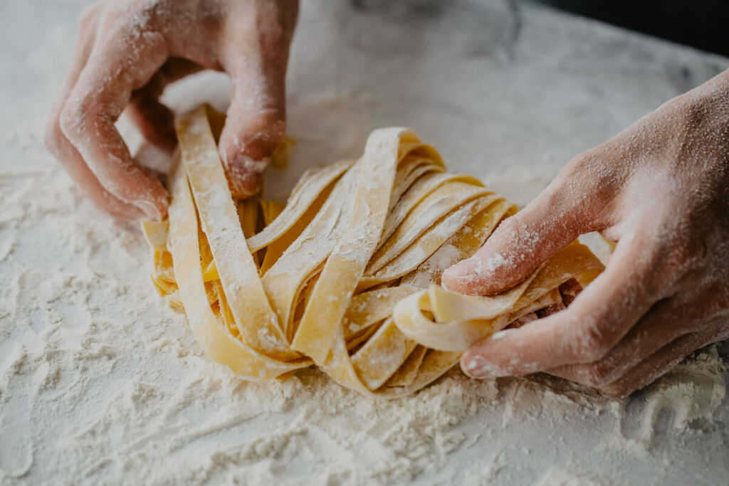 Closeup of process of making cooking homemade pasta