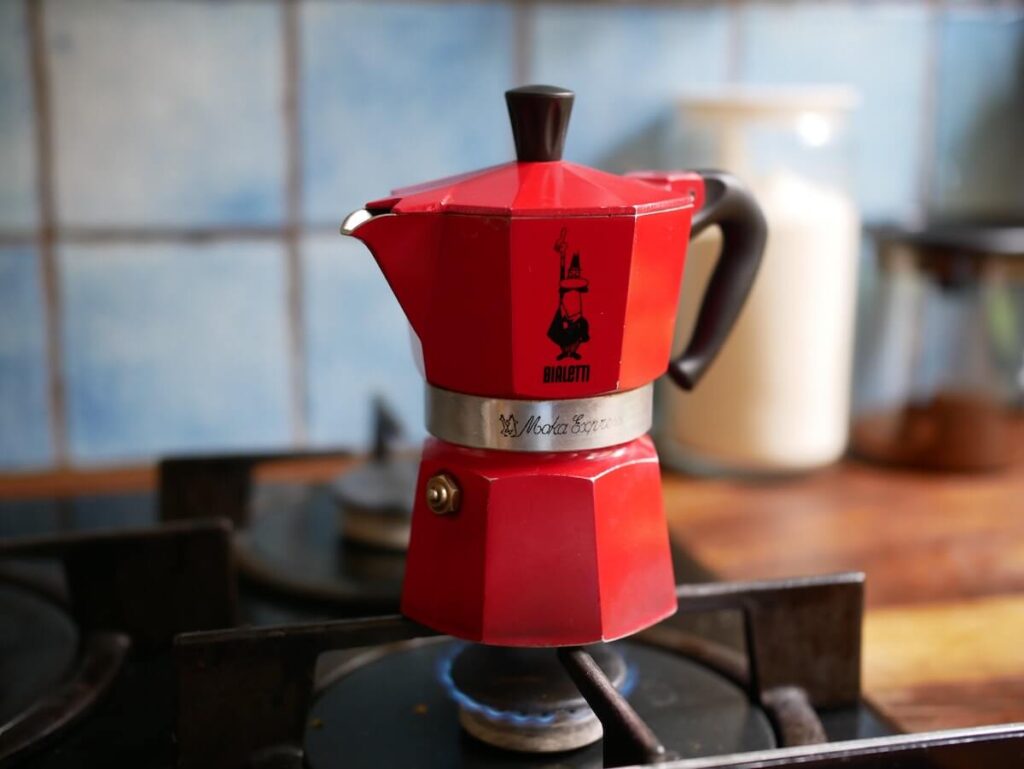 A Bialetti Moka Express 3-Cup red coffee maker brewing some delicious Lavazza coffee. The Moka pot is an important part of Italian coffee culture.