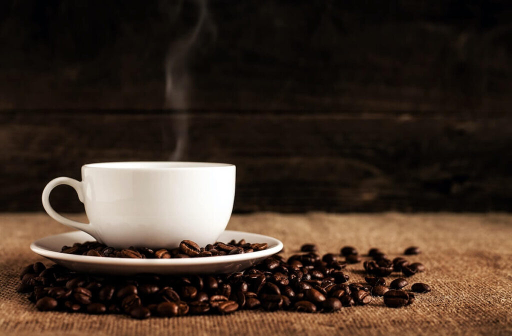 cup of coffee and coffee beans on a wooden table