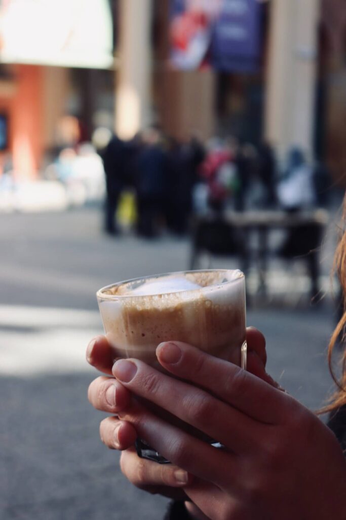 girl holding coffee with milk in Bologna, Italy