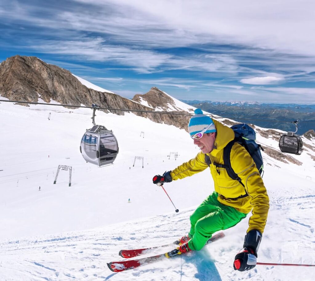 Skier skiing downhill during sunny day in high mountains, Kaprun glacier