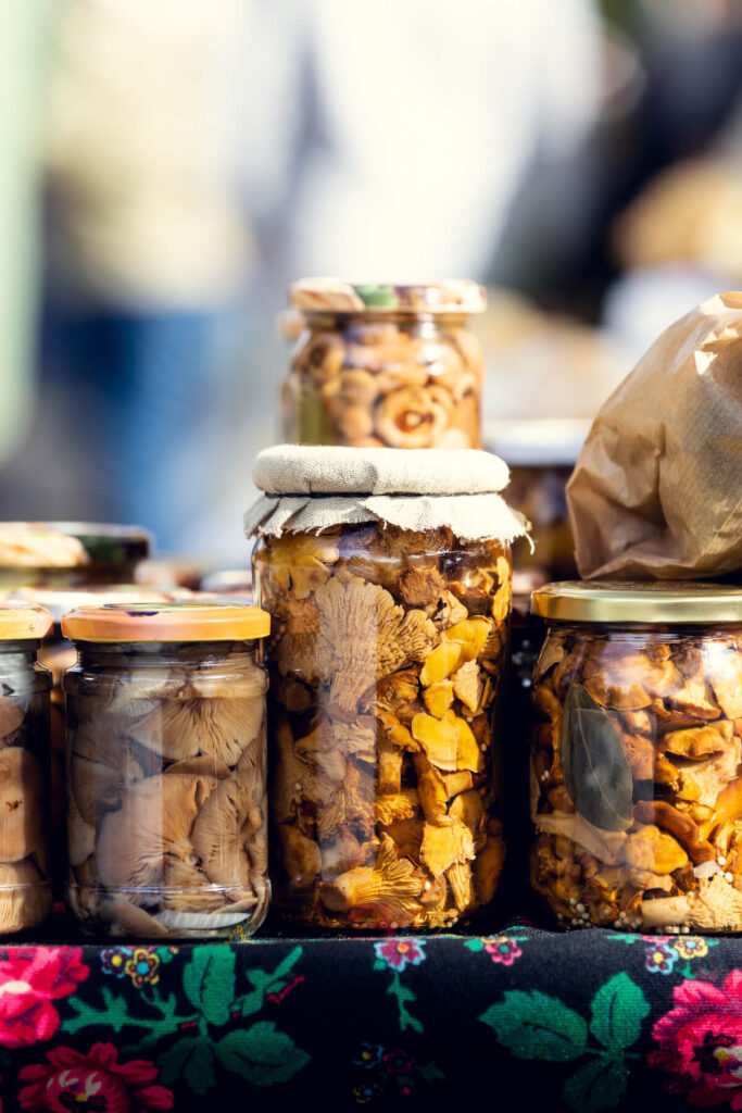 Regional pickled mushrooms sold in jars at the bazaar.