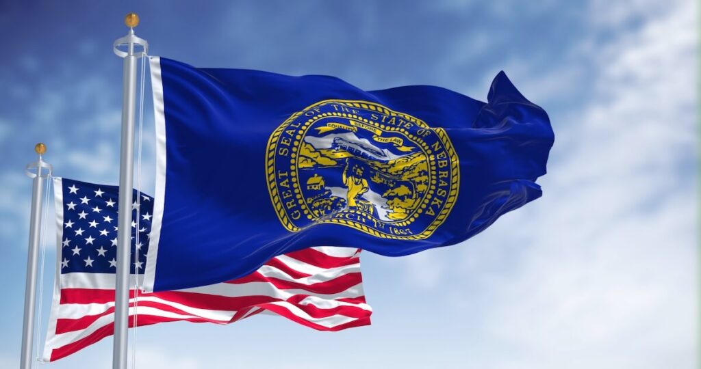 The Nebraska state flag waving along with the national flag of the United States of America