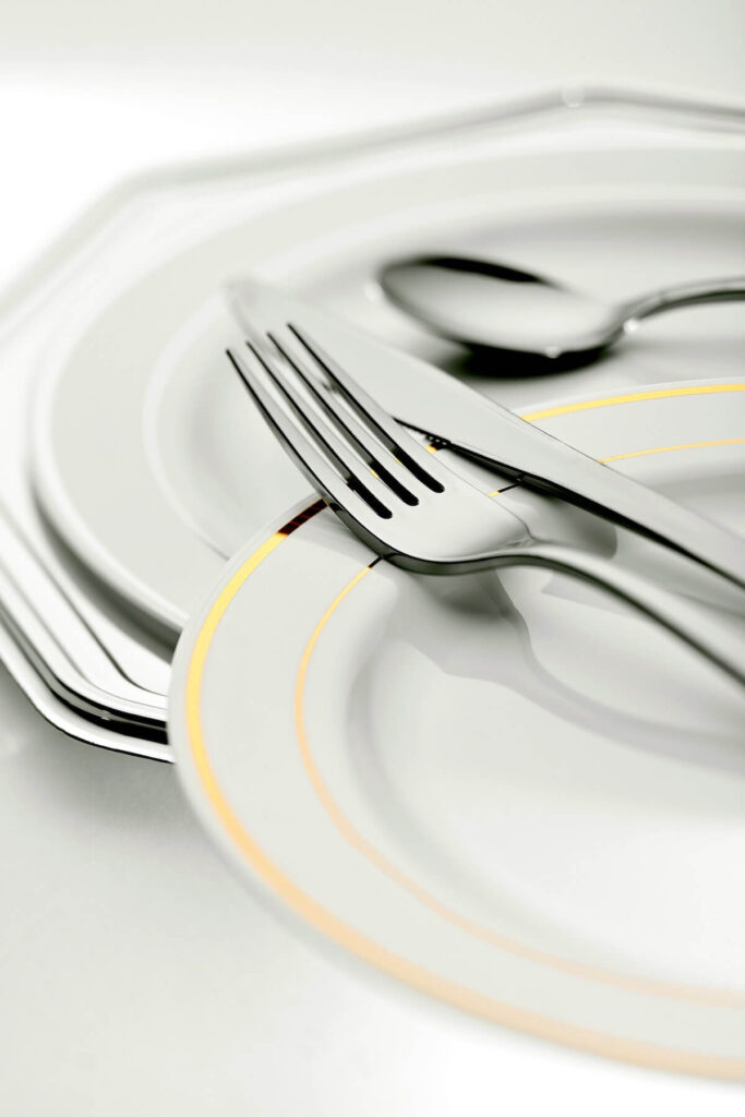 stainless steel fork, knife, and spoon on top of white plates
