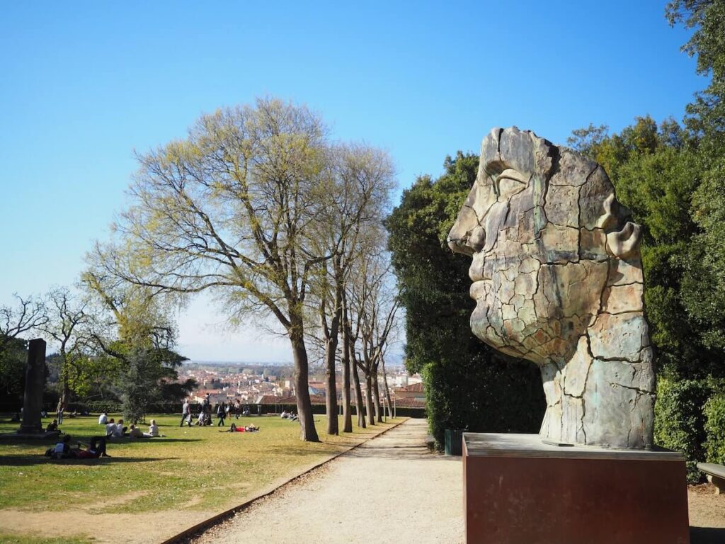 people on the lawn and sculpture at boboli gardens