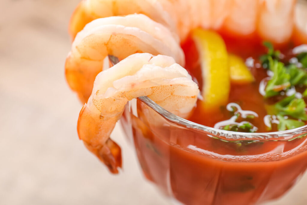 Glass with shrimp cocktail and tomato sauce