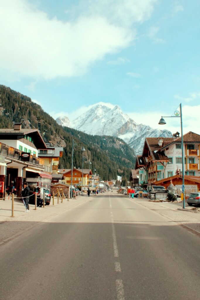 snow capped mountain towers over canazei