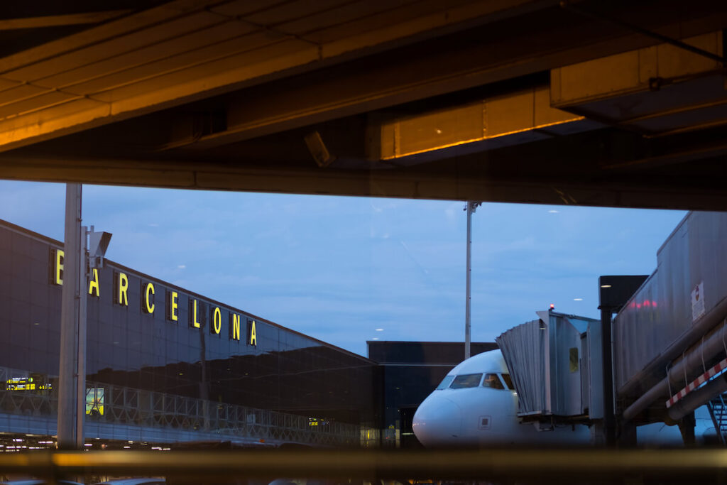 Glass facade and airplane as seen through the boarding area of Barcelona Airport, the main airport of Catalonia, Spain