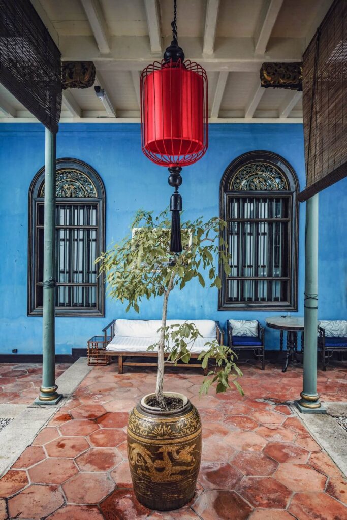 beautiful blue view of a red lamp and chinese vase with plant in cheon fatt tze mansion in george town penang in malaysia