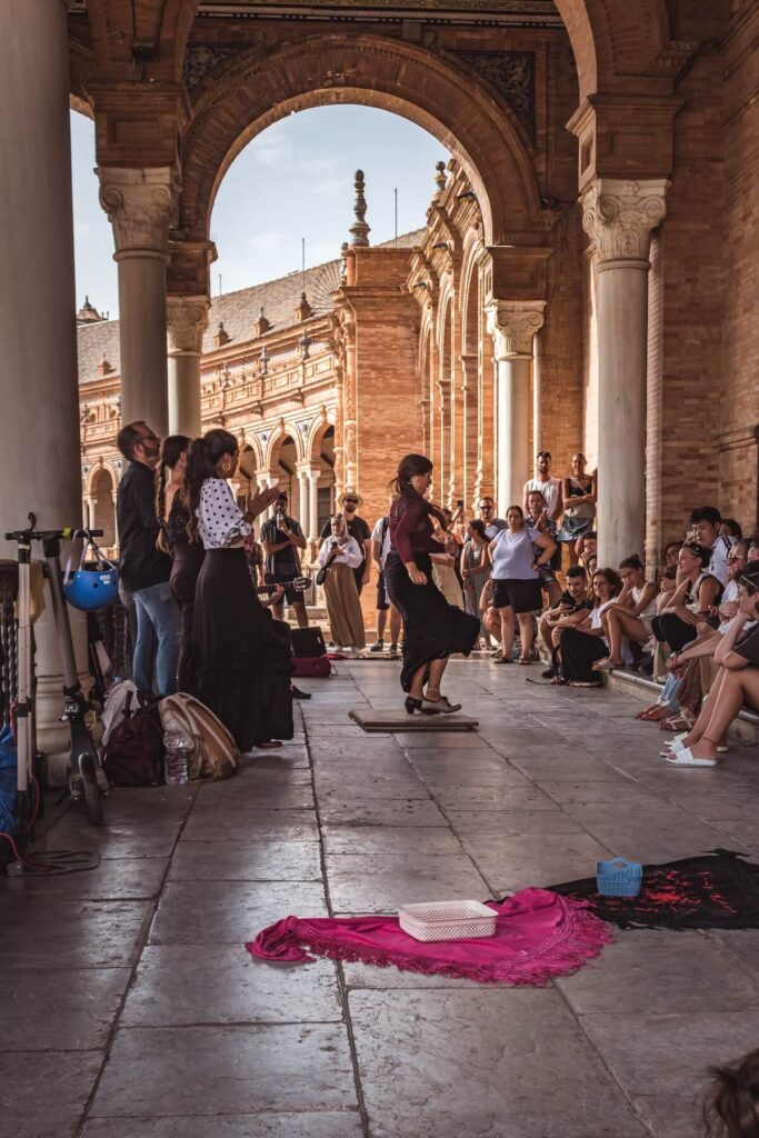 Flamenco dance group, singing and dancing with tourists watching in the corridor of the Palace of Plaza de España