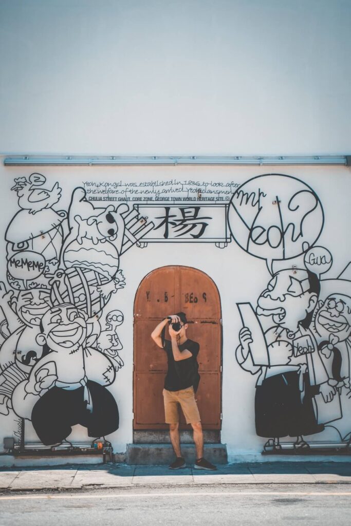 photographer standing by a mural in Georgetown, Penang