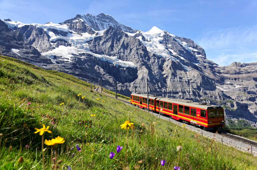 A tourist train travels on Jungfrau Railway from Jungfraujoch (Top of Europe) to Kleine Scheidegg
