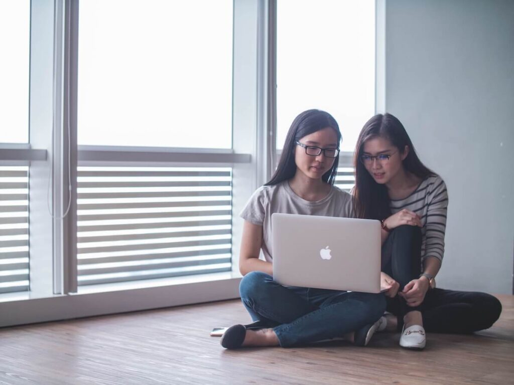 two Malaysian students looking at a laptop