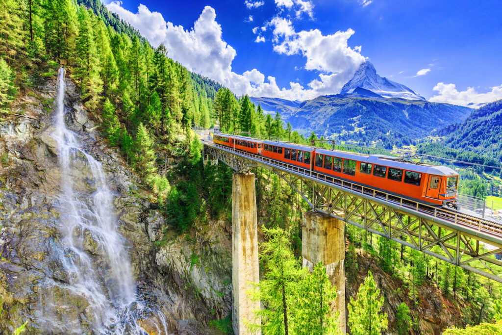 Zermatt, Switzerland. Gornergrat tourist train with waterfall, bridge and Matterhorn. Valais region.