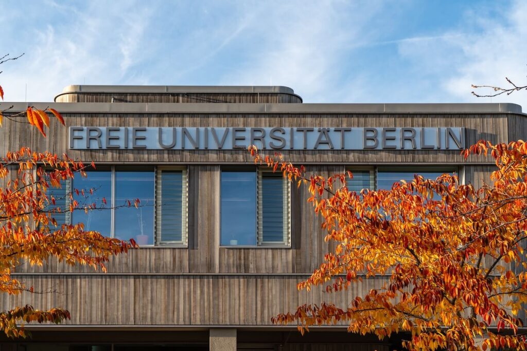 Freie Universität Berlin (FU), close-up of the lettering on the facade of a university building framed by decorative autumn leaves
