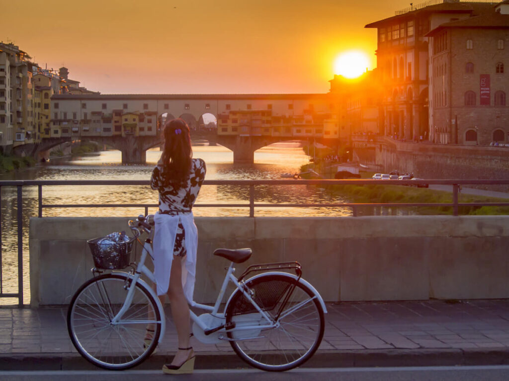 woman on a bike at Ponte Vecchio during sunset